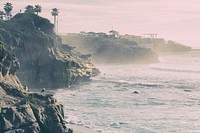 A hazy coastal shot of palm trees and ocean. Original public domain image from Wikimedia Commons