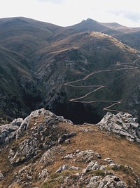 A view from a jagged ledge on a zigzagging road up the mountain. Original public domain image from <a href="https://commons.wikimedia.org/wiki/File:Zigzag_road_on_a_mountain_slope_(Unsplash).jpg" target="_blank" rel="noopener noreferrer nofollow">Wikimedia Commons</a>