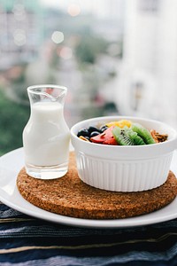 Milk and a bowl of fruit for a healthy breakfast. Original public domain image from Wikimedia Commons