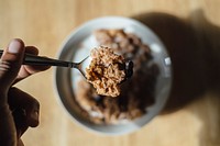 A person holding a spoon full of cereal over a bowl of cereal and milk. Original public domain image from <a href="https://commons.wikimedia.org/wiki/File:Cereal_with_Milk_(Unsplash).jpg" target="_blank" rel="noopener noreferrer nofollow">Wikimedia Commons</a>