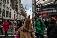 Crowd walks on a New York street among billboards, buildings, and a subway station, USA - 13 January 2017