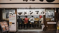Several people eating at a counter in an Asian café. Original public domain image from <a href="https://commons.wikimedia.org/wiki/File:In_Japan_(Unsplash).jpg" target="_blank" rel="noopener noreferrer nofollow">Wikimedia Commons</a>