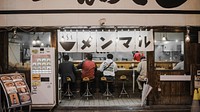 Several people eating at a counter in an Asian café. Original public domain image from Wikimedia Commons