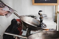 A person cooking mussels in a pot over a stove. Original public domain image from <a href="https://commons.wikimedia.org/wiki/File:Street_food_(Unsplash).jpg" target="_blank" rel="noopener noreferrer nofollow">Wikimedia Commons</a>