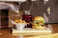 Cheeseburger, red juice drink, and a basket of fries at a restaurant. Original public domain image from Wikimedia Commons