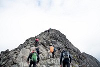 Hikers with backpacks summiting peaks of mountain. Original public domain image from <a href="https://commons.wikimedia.org/wiki/File:Hikers_at_peak_(Unsplash).jpg" target="_blank" rel="noopener noreferrer nofollow">Wikimedia Commons</a>