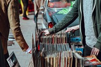 People browsing vinyl records at a stall on the street. Original public domain image from Wikimedia Commons