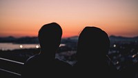 A silhouette of a couple during sunset looking out to Stavros Niarchos Foundation Cultural Center. Original public domain image from <a href="https://commons.wikimedia.org/wiki/File:Sunset_vibes_(Unsplash).jpg" target="_blank" rel="noopener noreferrer nofollow">Wikimedia Commons</a>