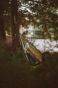 Two people in a hammock hanging between trees. Original public domain image from <a href="https://commons.wikimedia.org/wiki/File:Cozy_hammock_(Unsplash).jpg" target="_blank" rel="noopener noreferrer nofollow">Wikimedia Commons</a>