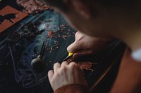 A person carving an insect out of wood. Original public domain image from Wikimedia Commons