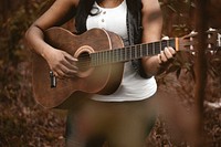Woman playing a guitar. Original public domain image from <a href="https://commons.wikimedia.org/wiki/File:Allef_Vinicius_2017-01-27_(Unsplash).jpg" target="_blank">Wikimedia Commons</a>