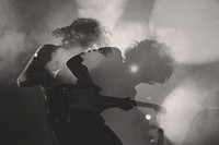 A black-and-white shot of a man playing electric guitar in double exposure. Original public domain image from Wikimedia Commons