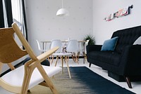 White chairs and a black sofa in a rest area in an office. Original public domain image from Wikimedia Commons