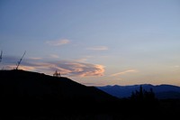 A silhouette of a mountain slope partly obscuring a tall mountain ridge on the horizon in the evening. Original public domain image from <a href="https://commons.wikimedia.org/wiki/File:Evening_in_Omarama_(Unsplash).jpg" target="_blank" rel="noopener noreferrer nofollow">Wikimedia Commons</a>