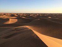 A series of dunes stretching to the horizon under the scorching sun. Original public domain image from <a href="https://commons.wikimedia.org/wiki/File:Sea_of_dunes_(Unsplash).jpg" target="_blank" rel="noopener noreferrer nofollow">Wikimedia Commons</a>