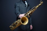 A man in suit holding a saxophone. Original public domain image from <a href="https://commons.wikimedia.org/wiki/File:AJ_O%27Reilly_2015_(Unsplash).jpg" target="_blank">Wikimedia Commons</a>