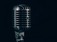 Close-up of a condenser microphone in a steel casing against a black background. Original public domain image from Wikimedia Commons