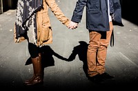 A couple in casual fall clothing holds hands in Edmonton, their shadow visible behind them. Original public domain image from <a href="https://commons.wikimedia.org/wiki/File:Holding_hands_with_shadow_(Unsplash).jpg" target="_blank" rel="noopener noreferrer nofollow">Wikimedia Commons</a>