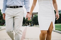 A dressed-up couple holds hands and strolls on a path through a Boston park. Original public domain image from Wikimedia Commons