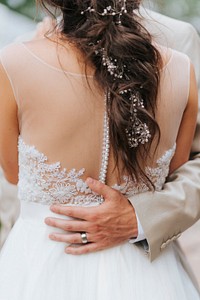 Groom wraps arm around bride's back at Fort Collins wedding. Original public domain image from Wikimedia Commons