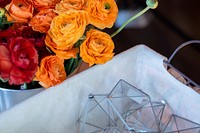 A large bouquet of red and orange roses in a bucket next to a basket with glass prisms. Original public domain image from <a href="https://commons.wikimedia.org/wiki/File:Flower_bouquet_and_prisms_(Unsplash).jpg" target="_blank" rel="noopener noreferrer nofollow">Wikimedia Commons</a>