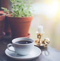 White ceramic cup filled with black coffee on top of saucer. Original public domain image from Wikimedia Commons