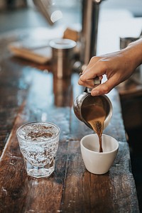 People pouring coffee in mug. Original public domain image from Wikimedia Commons