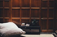 Coffee table and a pillow chair next to a wall with wooden panelling. Original public domain image from Wikimedia Commons