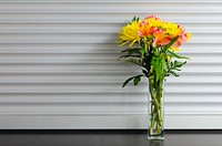 Glass vase holding yellow and red flowers. Original public domain image from Wikimedia Commons