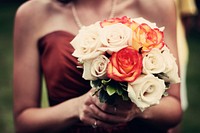 Low shot of bridesmaid holding a bouquet of roses walking down the aisle. Original public domain image from Wikimedia Commons
