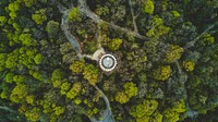 A drone shot of a round building in a wooded area with narrow footpaths. Original public domain image from <a href="https://commons.wikimedia.org/wiki/File:Lonely_Island_(Unsplash).jpg" target="_blank" rel="noopener noreferrer nofollow">Wikimedia Commons</a>