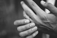 Groom touching his wedding ring on hand. Original public domain image from Wikimedia Commons