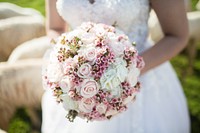 A bride with a round bouquet of white and pink flowers. Original public domain image from Wikimedia Commons