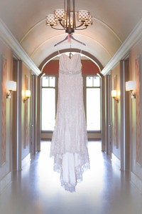 Thin wedding dress hangs from Chandelier in arched hall. Original public domain image from <a href="https://commons.wikimedia.org/wiki/File:Wedding_dress_hangs_from_chandelier_(Unsplash).jpg" target="_blank" rel="noopener noreferrer nofollow">Wikimedia Commons</a>