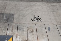 Bicycle with black frame on a textured, concrete sidewalk in Piraeus. Original public domain image from Wikimedia Commons