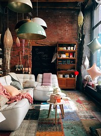 A living room having a brick wall, glass windows and containing a white sofa with throw pillows in Canada.. Original public domain image from <a href="https://commons.wikimedia.org/wiki/File:Furnished_living_room._(Unsplash).jpg" target="_blank" rel="noopener noreferrer nofollow">Wikimedia Commons</a>