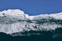 A tall steep mountain face against a blue sky in Jasper National Park. Original public domain image from Wikimedia Commons