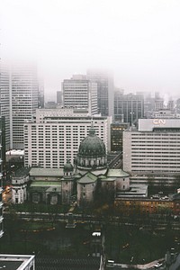 Cathedral-Basilica of Mary Queen of the World and high-rises in Montreal on a foggy day. Original public domain image from Wikimedia Commons