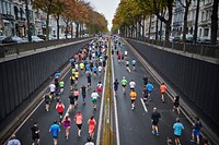 A large group of people running in a marathon in the middle of a street in Brussels. Original public domain image from Wikimedia Commons