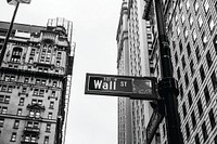 A street sign pointing to Wall Street in black and white. Original public domain image from Wikimedia Commons