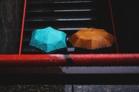 Two people carrying umbrellas on a wet staircase. Original public domain image from Wikimedia Commons