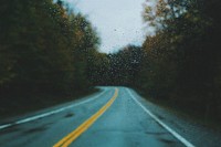 View through a wet windshield on a tree-lined asphalt road. Original public domain image from Wikimedia Commons