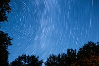 A blue night sky with star light trails above Fryeburg in the state of Maine. Original public domain image from Wikimedia Commons