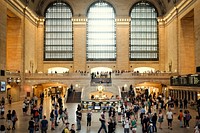 Commuters at Grand Central Station in front of three large, arched windows and a clock. Original public domain image from Wikimedia Commons