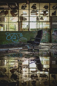 Abandoned urban warehouse with chair and water reflection with graffiti tags on wall, Sheffield United Kingdom. Original public domain image from Wikimedia Commons