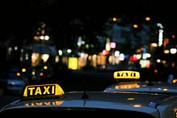 Taxis at night in Budapest with the city in the background. Original public domain image from Wikimedia Commons