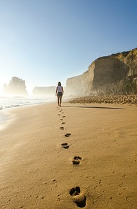 Woman walking on shore. Original public domain image from Wikimedia Commons