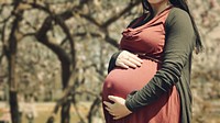 Pregnant woman holds her belly in autumn colors outdoors. Original public domain image from <a href="https://commons.wikimedia.org/wiki/File:Autumn_baby_to_be_(Unsplash).jpg" target="_blank" rel="noopener noreferrer nofollow">Wikimedia Commons</a>
