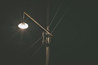 Single street lamp lit up by a power line at night. Original public domain image from <a href="https://commons.wikimedia.org/wiki/File:Dark_Walk_Alone_(Unsplash).jpg" target="_blank" rel="noopener noreferrer nofollow">Wikimedia Commons</a>