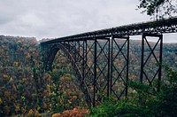 A long old steel bridge over a wooded ravine in Fayetteville. Original public domain image from <a href="https://commons.wikimedia.org/wiki/File:Old_steel_bridge_(Unsplash).jpg" target="_blank" rel="noopener noreferrer nofollow">Wikimedia Commons</a>